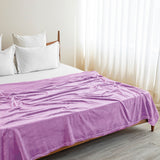 The Premium Bedsheet & Blanket Combo Set | Gift-Ready Box features a light purple floral cotton bedsheet, white pillows, and a plush blanket, creating an inviting look in any bright room with sheer curtains and wooden flooring.